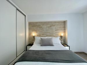 ベナルマデナにあるApartamento Beli Málagaのレンガの壁、大きなベッド付きのベッドルーム1室