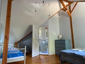 een slaapkamer op zolder met een bed en een badkamer bij DOM NA GROBLI in Dłużki