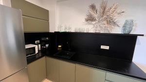 uma cozinha com um balcão preto e um micro-ondas em Tropical Apartment em Durrës