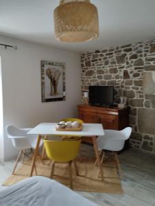 a dining room with a white table and chairs at Le Manoir de la Pichardière in Cherrueix