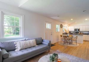 a living room with a blue couch and a kitchen at Luxurious 3 Bedroom House In Hampton in East Hampton