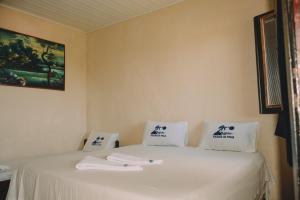 a bed with white sheets and white towels on it at A Pousada da Praia in São Luís +29 photos