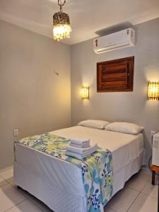 a bedroom with a bed with towels on it at Pousada Camocim Beach in Camocim