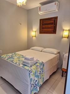 Pousada Grand Fortim في كاموسين: غرفة نوم عليها سرير وفوط
