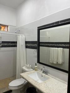 y baño con lavabo, aseo y espejo. en Brisa Bliss, en San Juan de Alima