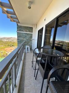 d'un balcon avec une table et des chaises et une vue. dans l'établissement Bristle Ridge Cozy Vacation Baguio, à Baguio