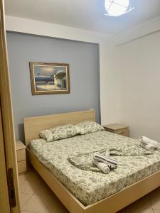a bedroom with a bed with a picture on the wall at Beach Apartments Durres in Durrës
