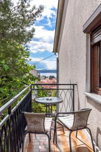 a patio with two chairs and a table on a balcony at Apartman Marco Polo in Selce