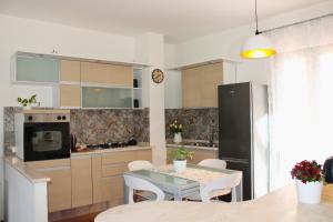 una cucina con tavolo e frigorifero nero di Dimidium Apartment a Guspini