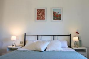 una camera con un letto con due lampade e due immagini di Dimidium Apartment a Guspini