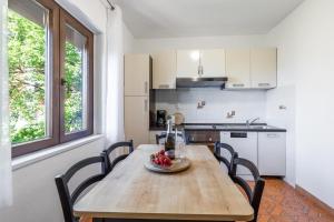 a kitchen with a table with a bowl of fruit on it at Apartman Marco Polo in Selce
