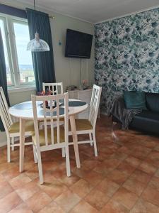 - une salle à manger avec une table, des chaises et un canapé dans l'établissement Stugor utanför Skövde 2 och 4, à Skövde