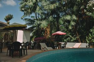 a swimming pool with chairs and tables and umbrellas at A Pousada da Praia in São Luís
