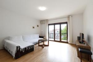 a living room with a white couch and a window at Apartman Marco Polo in Selce