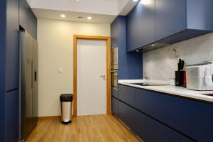 a kitchen with blue cabinets and a white counter top at Quinta dos Cardais by AnaLodges in São Vicente