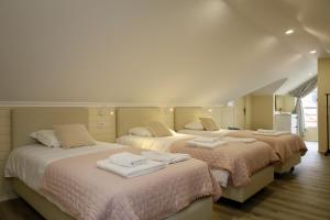 a bedroom with three beds with towels on them at Quinta dos Cardais by AnaLodges in São Vicente +70 photos