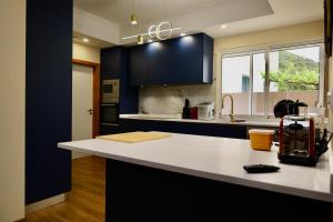 a kitchen with a white counter top and blue cabinets at Quinta dos Cardais by AnaLodges in São Vicente