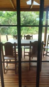 a table and chairs on a screened in porch at La casita del bosque in Punta Indio +11 photos