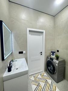 a bathroom with a washing machine and a sink at 2-room apartment ЖК Комфорт Сити near MEGA, flat 15 in Almaty