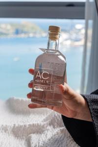 a person holding a bottle of alcohol in their hand at AC Hotel By Marriott Santa Marta in Santa Marta