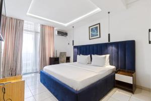 a bedroom with a large bed with a blue headboard at ORANGE ISLAND in Lagos