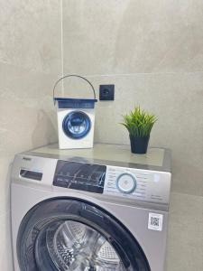 a washing machine with a plant on top of it at 2-room apartment ЖК Комфорт Сити near MEGA, flat 15 in Almaty