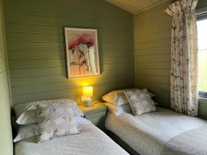 A bed or beds in a room at The Lodge at Blackhill Farm