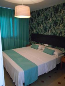 a bedroom with a large bed with green curtains at Beach Boys Resort Men Only solo hombres in Maspalomas +37 photos