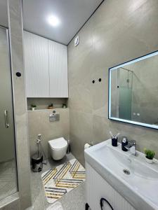 a bathroom with a white sink and a toilet at 2-room apartment ЖК Комфорт Сити near MEGA, flat 15 in Almaty