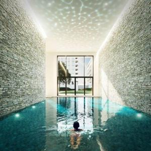 a person in a swimming pool in a building at Enjoy the Belgian coast with indoor heated swimmingpool and fitness in Ostend