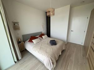 a bedroom with a bed with a backpack on it at Enjoy the Belgian coast with indoor heated swimmingpool and fitness in Ostend +8 photos