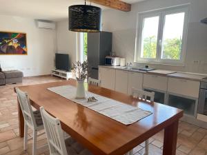 una cucina e una sala da pranzo con tavolo e sedie in legno di Olea Mar apartma a Pobegi