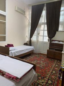 a room with two beds and a large window at Timur The Great in Samarkand