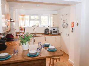 una cocina con una mesa de madera con platos azules. en Lyme Views, en Lyme Regis