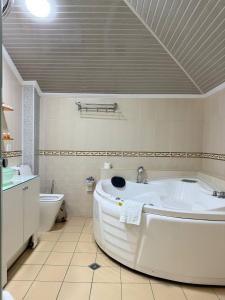 撒马尔罕阿尔巴酒店的带浴缸和马桶的白色浴室