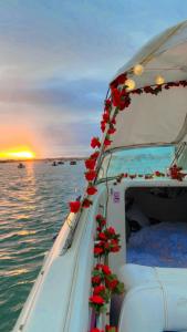 Un barco con flores rojas en la parte trasera. en GuestBoat Milagre en Faro