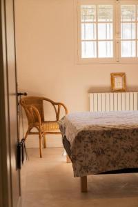 a bedroom with a bed and a chair and a window at Appartement dans maison de campagne lumineuse in Orange