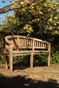 a wooden bench sitting in front of a tree at Appartement dans maison de campagne lumineuse in Orange