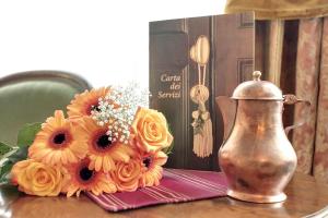 un vase et un bouquet de fleurs sur une table dans l'établissement Palazzo Schiavoni Residenza d'epoca & Suite-Apartments, à Venise