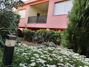 a pink house with a garden in front of it at Miran in Ivanica