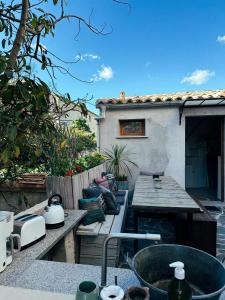 a outdoor kitchen with a sink and a house at Casaluna, chambre climatisée dans maison de village in Sotta +18 photos