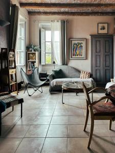 a living room with a couch and chairs at Casaluna, chambre climatisée dans maison de village in Sotta
