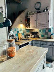 a kitchen with a counter top with a clock on the wall at Casaluna, chambre climatisée dans maison de village in Sotta
