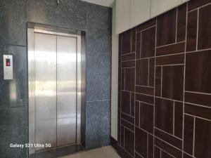 um corredor com um elevador de metal num edifício em MSPride em Tirupati