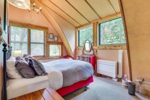 Un dormitorio con una cama en una habitación con ventanas. en Riverfront Skykomish Cabin with Private Hot Tub!, en Skykomish