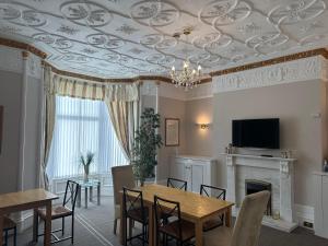 een eetkamer met een schuin plafond en een tafel en stoelen bij Third House Guest House in Aberdeen
