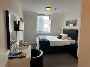 ein Hotelzimmer mit einem Bett und einem Stuhl in der Unterkunft Third House Guest House in Aberdeen