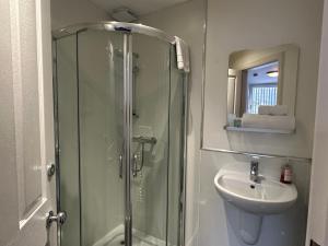 ein Bad mit einer Dusche und einem Waschbecken in der Unterkunft Third House Guest House in Aberdeen