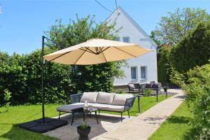 un patio con mesa, sombrilla y sillas en The Secret Garden – Keszthely, en Keszthely