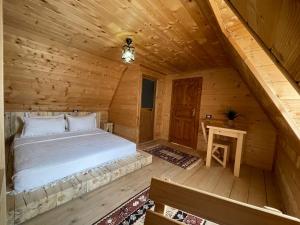 a bedroom with a bed in a log cabin at Guesthouse "Gjin Thana" in Theth